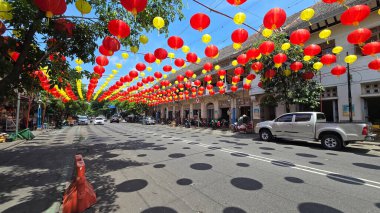 Canlı kırmızı ve sarı fenerler, Çin 'in yeni yılını ve geleneksel kültür dekoru kutlamalarını temsil eden huzurlu mavi gökyüzünün altında açık balkonlarda asılı duruyor. arkaplan için iyi