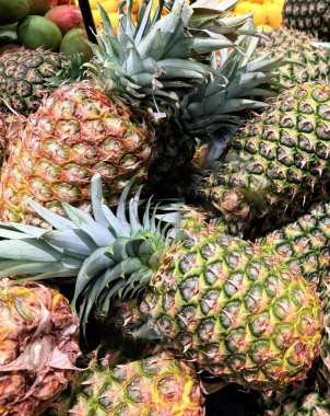 Tropikal bir atmosfer sergileyen taze, olgun ananasların renkli bir görüntüsü. Parlak ve detaylı görüntü meyvelerin sulandırıcılığını ve doğal çekiciliğini vurgular..