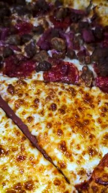 Tahta bir tahtanın üzerinde servis edilen peynirle et severlerin karışımından oluşan lezzetli bir pizza. Doldurulmuş altın peynir ve erimiş peynir taze ve karşı konulmaz lezzetleri vurgular ve ağız sulandırıcı bir mutfak deneyimi yaratır..