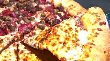 Tahta bir tahtanın üzerinde servis edilen peynirle et severlerin karışımından oluşan lezzetli bir pizza. Doldurulmuş altın peynir ve erimiş peynir taze ve karşı konulmaz lezzetleri vurgular ve ağız sulandırıcı bir mutfak deneyimi yaratır..