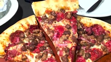 Tahta bir tahtanın üzerinde servis edilen peynirle et severlerin karışımından oluşan lezzetli bir pizza. Doldurulmuş altın peynir ve erimiş peynir taze ve karşı konulmaz lezzetleri vurgular ve ağız sulandırıcı bir mutfak deneyimi yaratır..