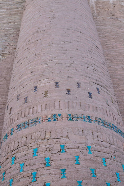 старинное историческое здание вблизи, куски синей майолики в стене в Ичан-кала, исторические и архитектурные памятники в Хиве, Узбекистан