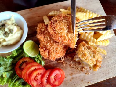 Tahta tabakta balık ve patates kızartması