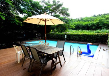 Oturup yüzme havuzunun yanında dinlenmek için masa ve sandalyeler..