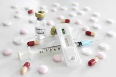 Covid-19 antijen test kiti, Vial of Covid-19 aşı, beyaz arka planda izole edilmiş iğne ve ilaçlarla dolu 1 ml plastik şırınga.