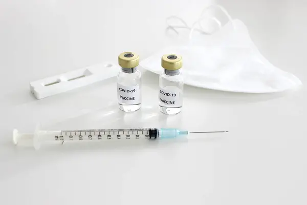 Covid-19 'un önlenmesi: Covid-19 aşısı, Covid-19 antijen test kiti ve beyaz arka planda maske
