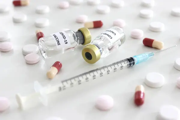 Covid-19 aşısı şişesi, beyaz arka planda izole edilmiş iğne ve uyuşturuculu 1 ml plastik şırınga.