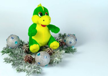 Noel baloları ve koniler arasında köknar dalları üzerinde oyuncak ejderha
