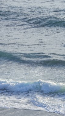 Sakin sahil, yumuşak dalgalar, altın güneş ışığı