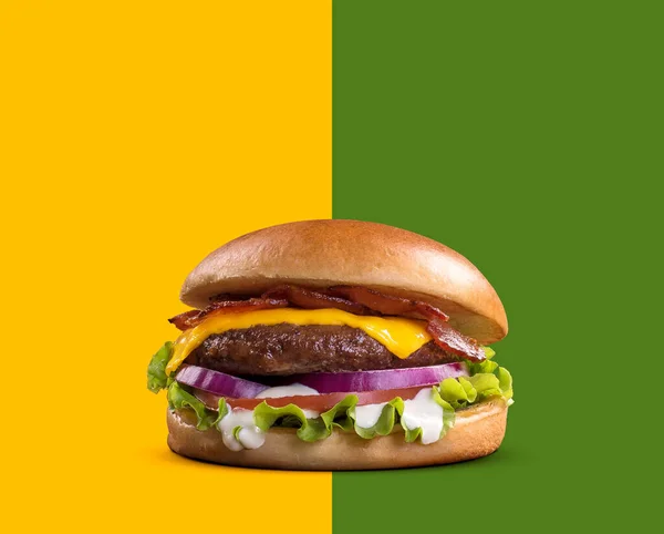 Fresh tasty burger on green and yellow background. cheese beef burger consists of bun bread, lettuce, tomato, onion, mayonnaise, and cheddar cheese