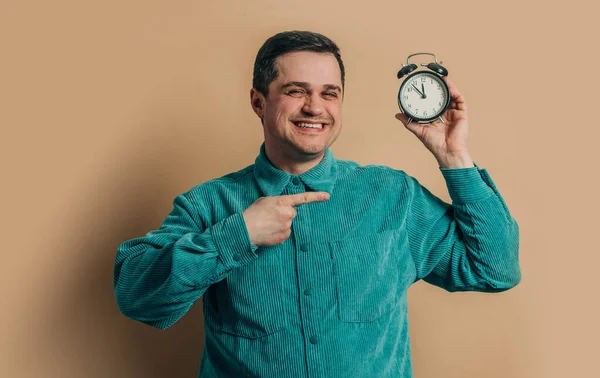 Stylish Caucasian Man Green Shirt Vintage Alarm Clock Brown Background Stockfoto