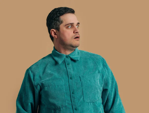 Surprised Caucasian Man Green Shirt Brown Background Rechtenvrije Stockfoto's