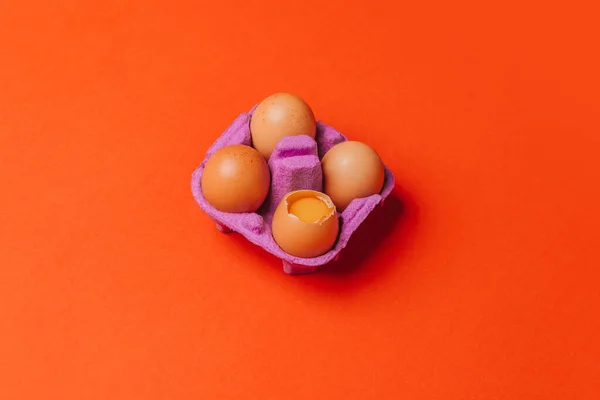 Cuatro Huevos Pollo Caja Huevo Púrpura Sobre Fondo Naranja Vista — Foto de Stock