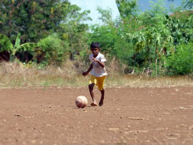 Maumere, Flores, Endonezya - 23 Mayıs 2023: Asyalı çocuklar sahada futbol oynuyorlar.
