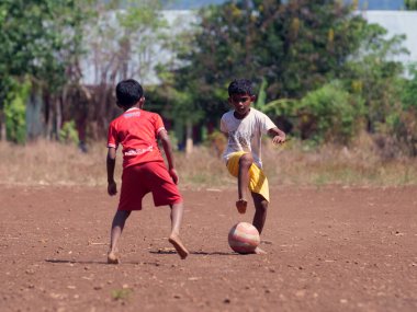 Maumere, Flores, Endonezya - 23 Mayıs 2023: Asyalı çocuklar sahada futbol oynuyorlar.