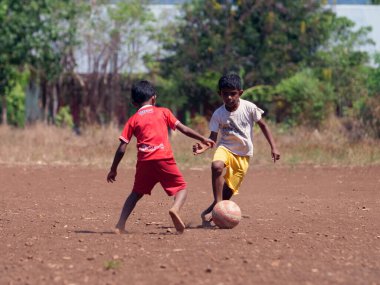Maumere, Flores, Endonezya - 23 Mayıs 2023: Asyalı çocuklar sahada futbol oynuyorlar.