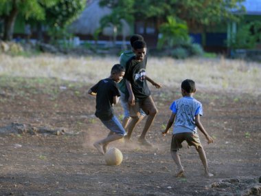 Maumere, Flores, Endonezya - 23 Mayıs 2023: Asyalı çocuklar sahada futbol oynuyorlar.
