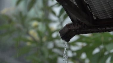 Evin çatısından damlayan yağmur damlaları.