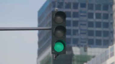 Arka planda binalar olan trafik ışıklarını kapat
