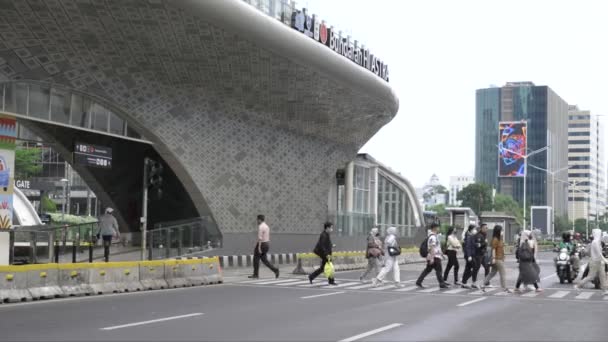 ジャカルタ インドネシア Jan02 2023 オフィスワーカーがバンダンHiバス停への道を横断しています — ストック動画