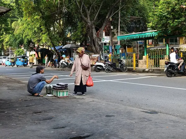 Jakarta, Endonezya - 2 Haziran 2024: Bir kasetçi ile bir alıcının annesi arasında yol kenarında etkileşim