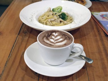 Tahta bir masada bir fincan sıcak çikolata.