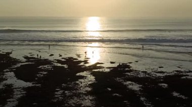 Bali, Endonezya - 15 Ağustos 2024: Bali Endonezya 'daki Uluwatu plajında günbatımının hava görüntüleri.