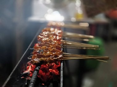 Parlak kömür közleri üzerinde kızaran satay 'ın yakın plan çekimi..