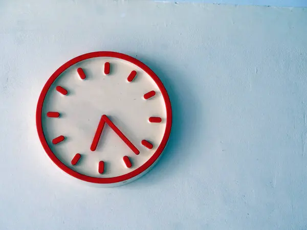 Beyaz duvardaki kırmızı duvar saati. Zaman azalıyor. Boşluğu kopyala