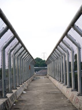 Şehir manzarasına bakan metal çitli yürüyüş yolu.