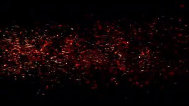 Soyut parçacıkların ateş akışı siyah zemin üzerinde soldan sağa doğru kıvılcım saçıyor. Ateş közleri arka plan dekorasyonu. İzole edilmiş siyah arkaplan.
