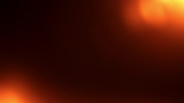 在黑色背景上的橙色红光学镜片和左上角和左下角闪光灯的散射光 — 图库视频影像