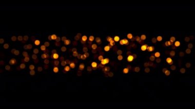 4K 3D dikişsiz döngü altın turuncu bokeh parçacıkları projenin ekran örtüsü için karanlıkta soyut olarak parlıyor. Soyut hareket arkaplan parlayan parçacıklar sihirli altın bokeh ışık dalgaları 