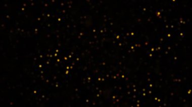 Siyah soyut arkaplan üzerinde turuncu altın renkli sahte parçacıklar parlıyor. 4K 3D döngü animasyonu. Yanıp sönen parçacıklar bokeh parçacıkları döngü etkisi arka planı.