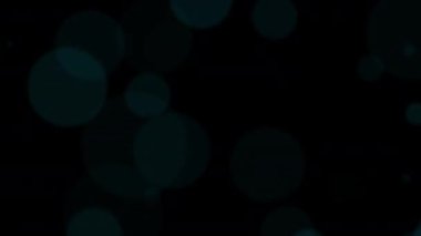 Güzel bir döngü hareket ediyor. Büyük mavi bulanık bokeh baloncukları hareket ediyor. Işıklar siyah soyut arkaplanda hareket ediyor. Siyah arkaplanda mavi bokeh parçacığı.