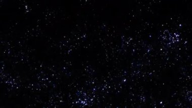 Animasyon döngüsü yanıp sönen beyaz toz yıldızı parçacıkları siyah soyut arka planda yukarı doğru akar. Alevli, mavi, parlayan, yanan kül parçacıklarının animasyonu..