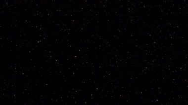 Parıldayan parlak beyaz yıldız parçacıkları siyah soyut arkaplan üzerine düşen animasyonlar. Alevli, parlayan yeşil uçan kor kül parçacıklarının animasyonu.