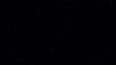 Animasyon döngüsü parlayan yıldız parçacıkları siyah soyut arkaplanda akar. Alevli, parlayan, yanan kül parçacıklarının animasyonu.