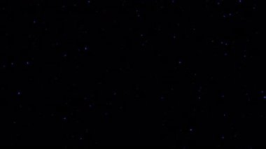 Döngü animasyonu yüzen mavi toz parçacıkları siyah soyut arka planda akar. Parlayan kor yanan kül parçacıkları.