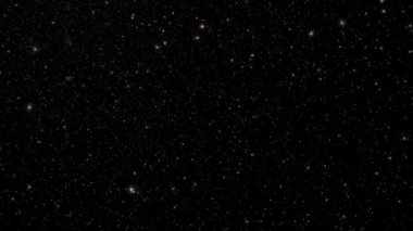 Parlak toz yıldızı parçacıkları siyah soyut arkaplanda hareket akışı sağlar. Siyah arkaplan hareket başlıklarında parlayan yıldızlar parçacığı sinematik