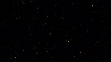 Soyut animasyon döngüsü yanıp sönen altın yıldız parçacıkları siyah arkaplanda akıyor. 4K 3D kusursuz altın halkalı bokeh parçacıkları havada uçuşuyor..