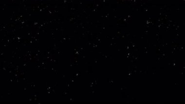 Siyah soyut arka planda parlayan beyaz toz yıldızı parçacıkları. Alevli, yeşil, parlayan, yanan kül parçacıklarının canlandırması.