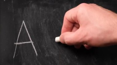 Eğitim harfleri, alfabe harfleri tahtada, beyaz tebeşir.