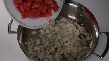 Domatesleri ekleyin, tencereye tabakla domates ekleyin.