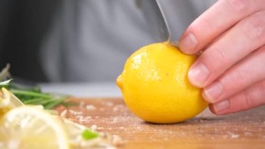 Limon keser, beyaz gömlek aşçısı bıçakla sarı limon keser.