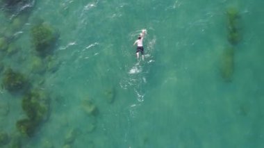 Denizde yüzen, açık denizde yüzen bir adam.