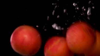 Sudaki şeftaliler, dönen şeftaliler, yavaş çekim, siyah arkaplan