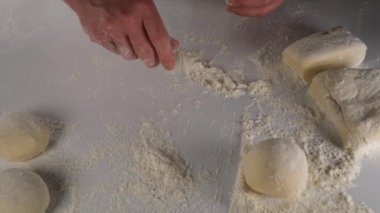 sprinkling flour, chef sprinkling flour on the bench