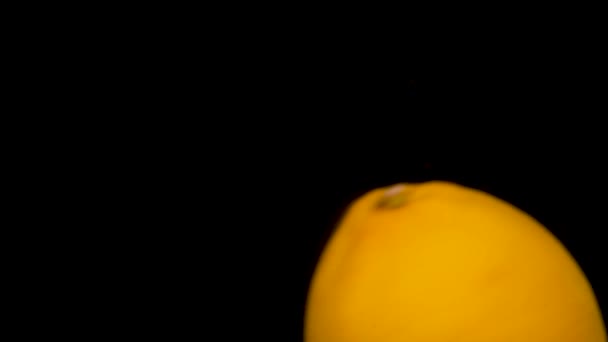レモン黄色のレモンが黒い背景に水に飛び散る — ストック動画