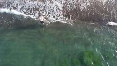 Denizde yüzen, açık denizde yüzen bir adam.